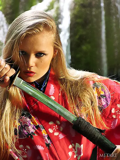 Blond-haired babe in a sexy kimono posing naked by the waterfall