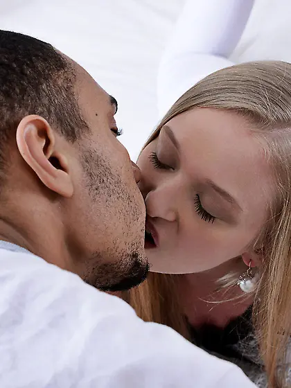 Skinny blonde enjoying intense interracial fucking on a big bed