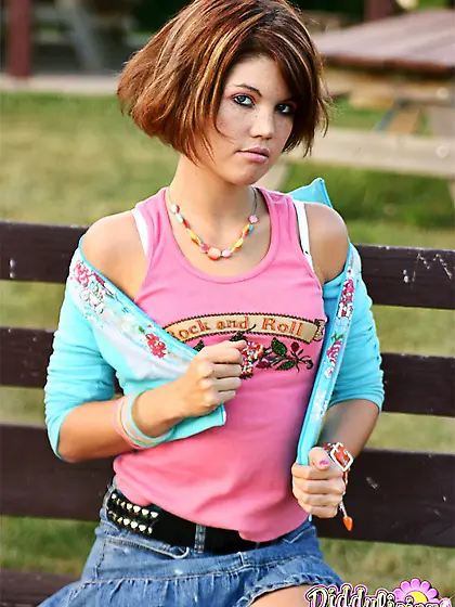 Beautiful young girl flashes her white panties on the bench in t