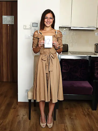 Mina K smiling as she removes her dress and flaunts her goods