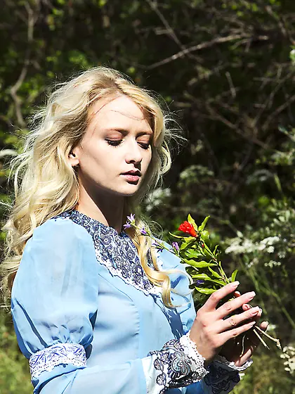 Graceful blonde in ancient clothes shows her pussy on the grass