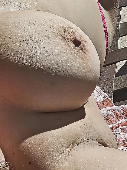 Young wife topless tanning