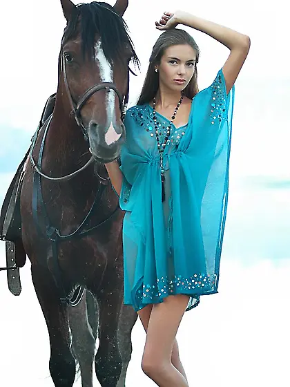 Horse girl posing next to a wild stallion in a outdoor erotic sh