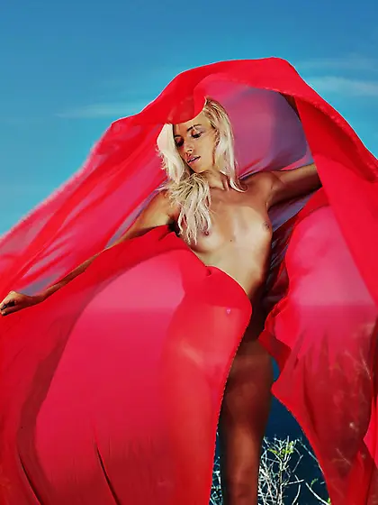 Naked blonde girl Adele B enjoying the light wind on top of the