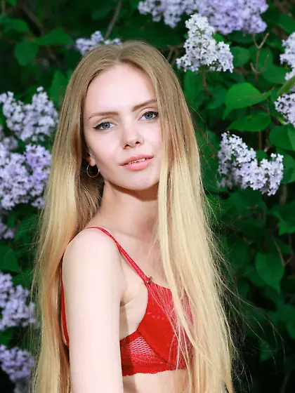 Pale-skinned blonde shamelessly takes off her red lingerie outdo