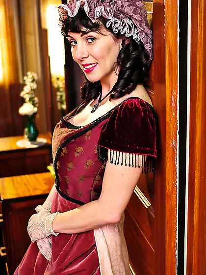 Smiling brunette housemaid is posing when black employer catches