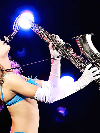 Seductive Sandra C plays saxophone and takes off her tiny outfit