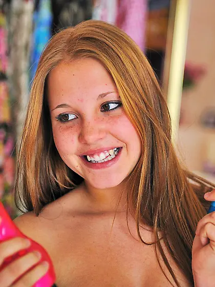 Brown-haired babe showing her cute face while picking toys for s