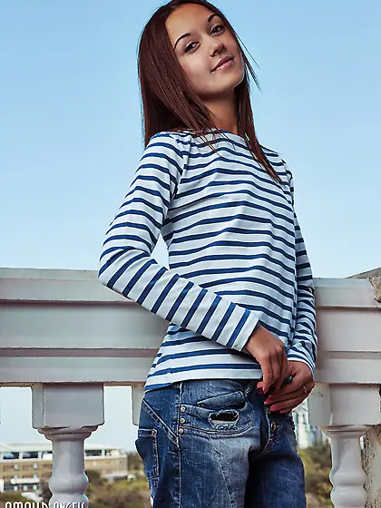 Woman in striped top and jeans takes them off exposing her tan l