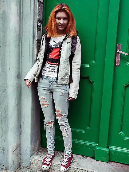 Redheaded girl in a colorful outfit shows her luxurious little p