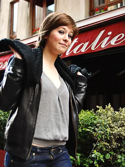 Playful short-haired lassie pulls off sweater to erotically pose