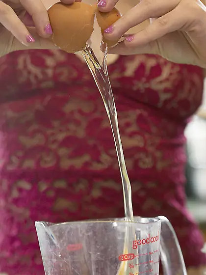 Stunning brunette breaks some eggs to make an omelet,  gets naked