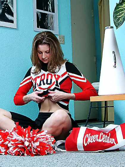 Smiling uniformed cheerleader Lisa Marie takes off her red panti