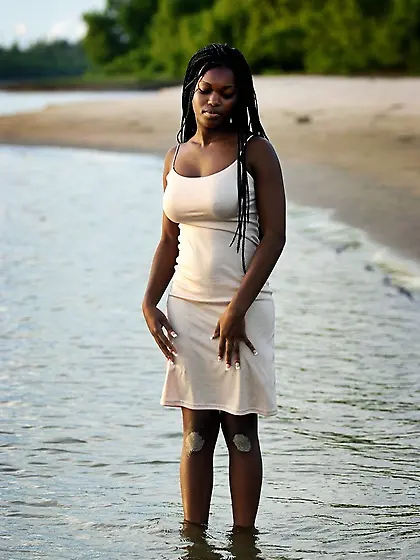 Black girl with perfect breasts shows her wet body while outdoor