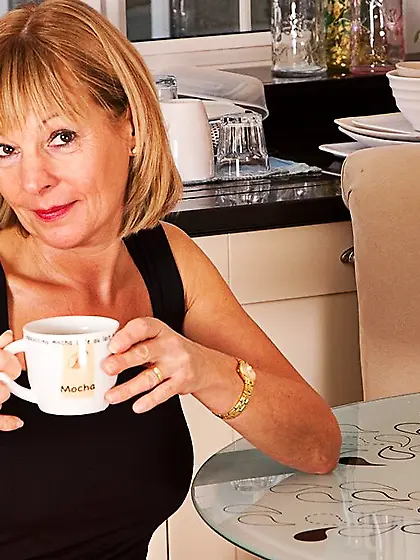 Busty mature lady Elaine Anilos in boots takes off her long red