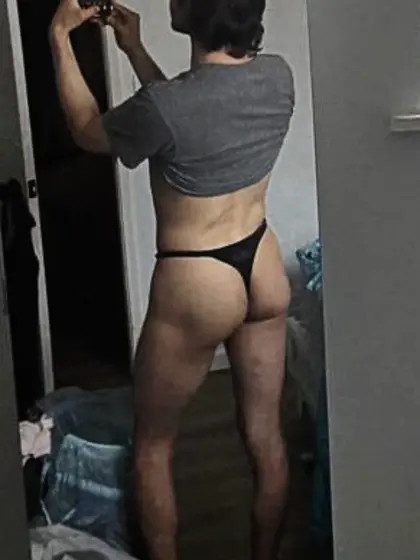 Posing in front of a mirror in a thong.