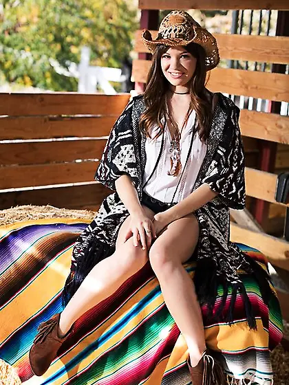 Cowgirl comes to the barn where she poses after stripping down t