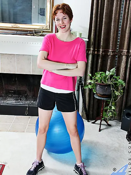 Sexy redhead milf Gigi Anilos is on the fitball playing beads in