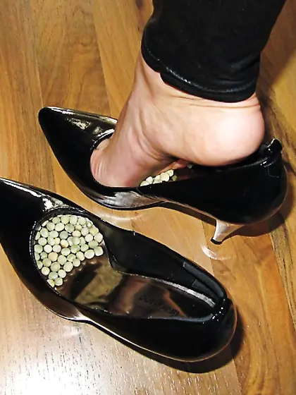 Foot torture with peas in high heels, leggings and corset