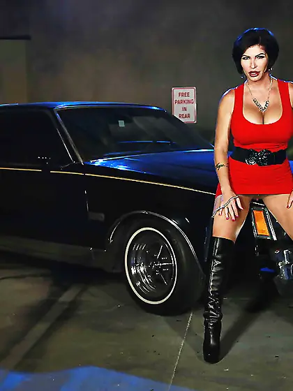 Diva exposes big round titties by big round wheels of a black ca