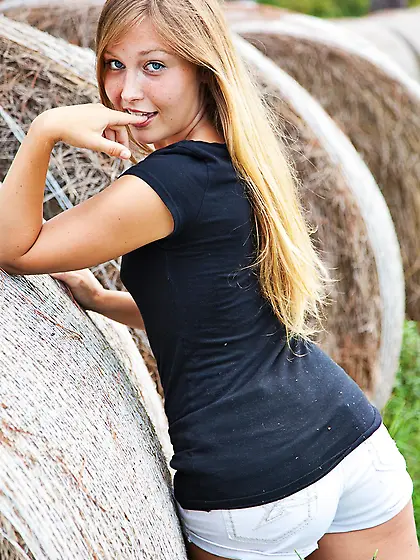 Breen is stripping down near a haystack on the grass