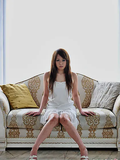 Beautiful girl from Japan in white dress prefers to sit on white