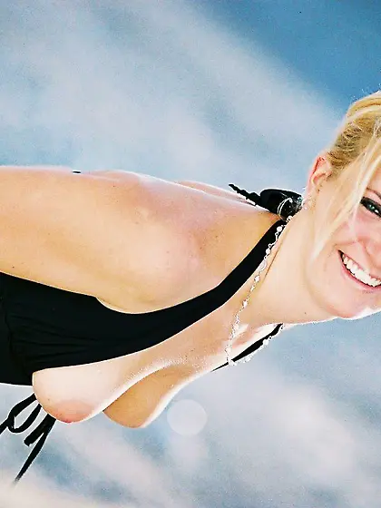 Long-legged blonde showing her appealing body in a hot outdoor g