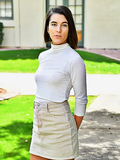 Beautiful girl hugs a tree and shoves yellow vegetables in sweet