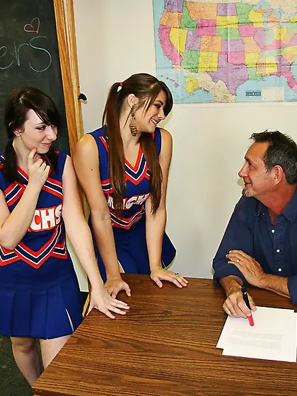 Cheerleaders Pocahontas and Dakota Charms stroke their teacher a