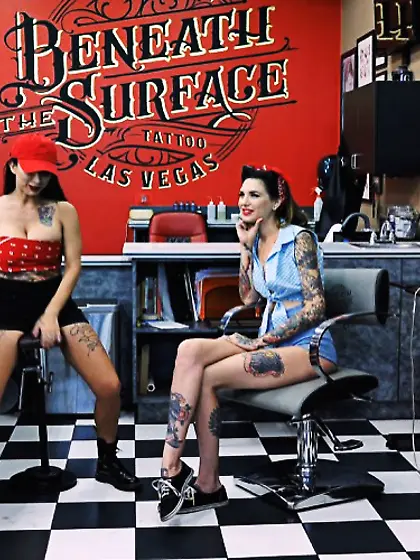 Brunettes share cock at tattoo shop