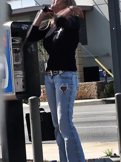 Marvelous chick with long hair is talking on the phone.  Her body