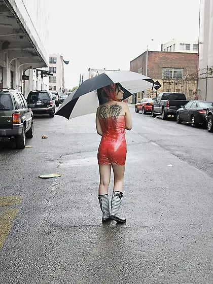 Concupiscent student in red plastic goes under a bridge to flash