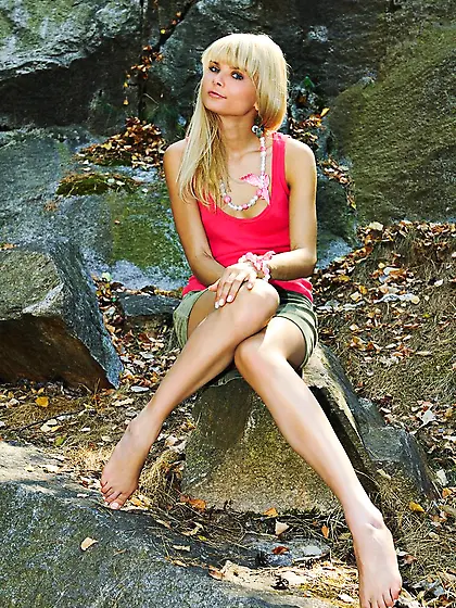 Playful blond-haired beauty smacking her firm little ass outdoor