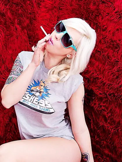 Horny blonde babe Lynn Pops strips on the bed and shows her fuck