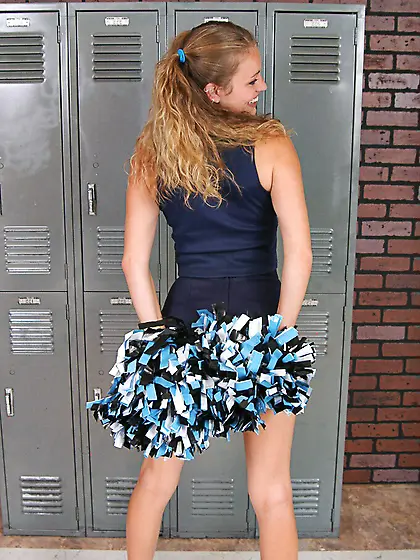 Curly haired slim girl Daisy May takes off her blue uniform and