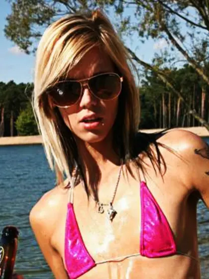 Oiled-up, flat-chested blonde on beach