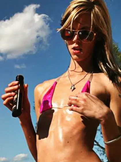 Oiled-up,  flat-chested blonde on beach