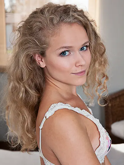 Curly-haired blonde takes off her white lingerie to show off her