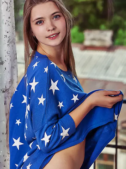 Cheerful blonde takes off her oversized shirt with stars and get