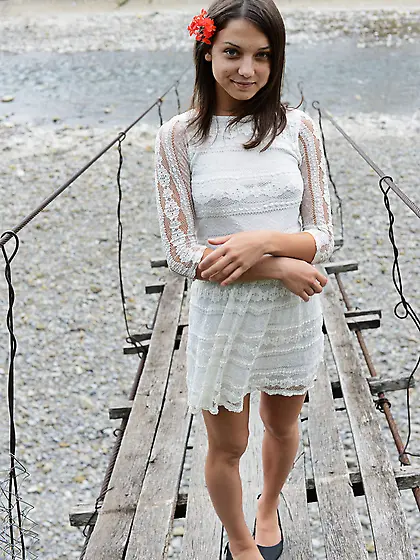 Frisky girl enjoys posing naked on top of a suspension bridge