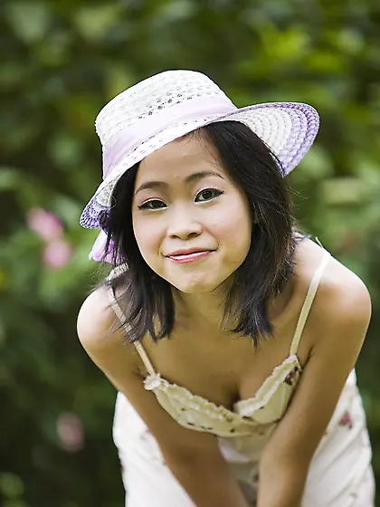 Asian chick in a funny hat strips naked to fool around outdoors