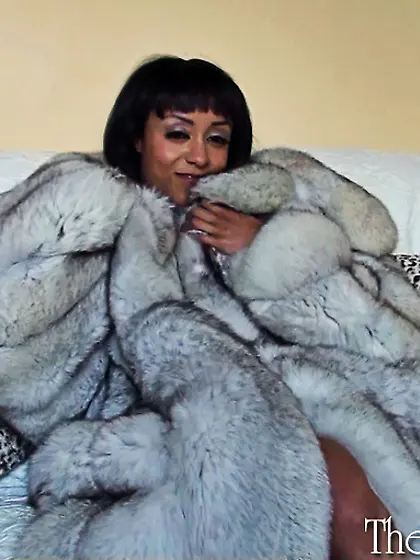 Ebony vixen posing naked in an ice fox coat