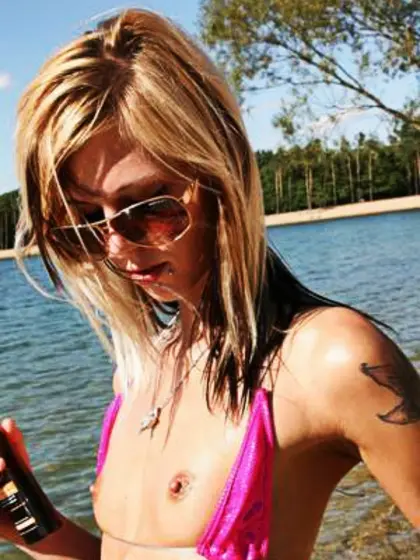 Oiled-up,  flat-chested blonde on beach