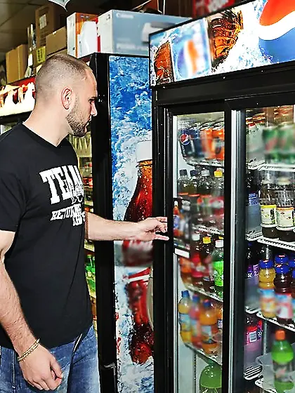 Glasses-wearing blonde in a black thong rides cock in a store