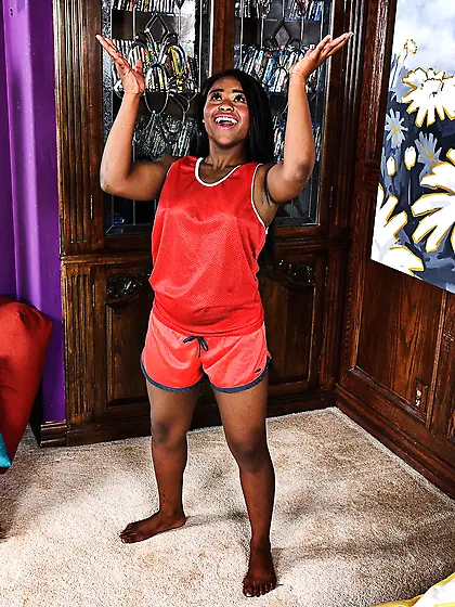 Lascivious Mulatto lassie in a red tracksuit throws basketball a