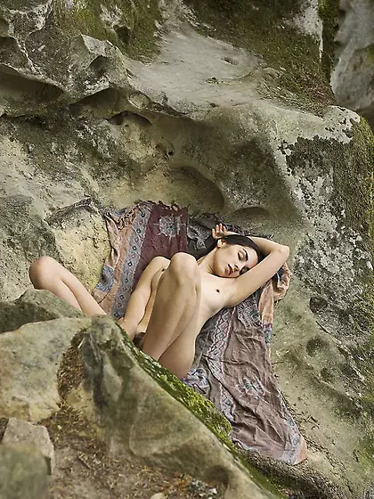 Naked brunette nudist showing her long legs in a very scenic spo
