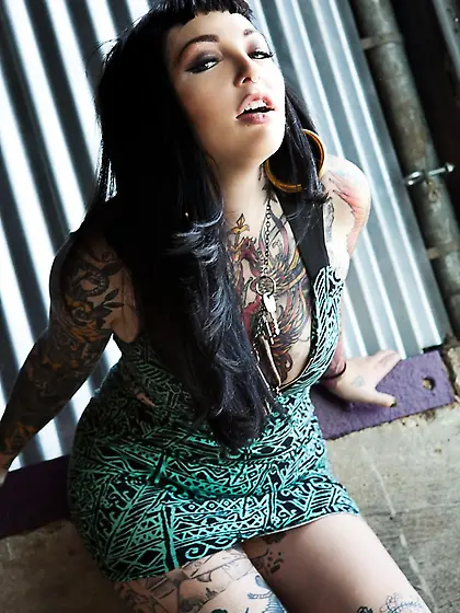 Tattooed brunette with hoop earrings shows how her smooth pussy