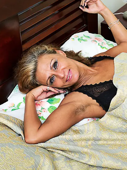 Tanned mature wakes up in the ideal mood to massage her dripping