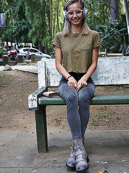 Veronica Leal poses on hood in green shirt and tight jeans