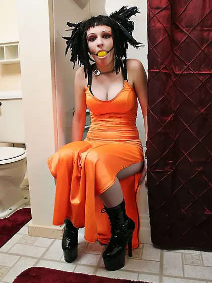 Beautiful female in orange has feathers in her hair and she spre